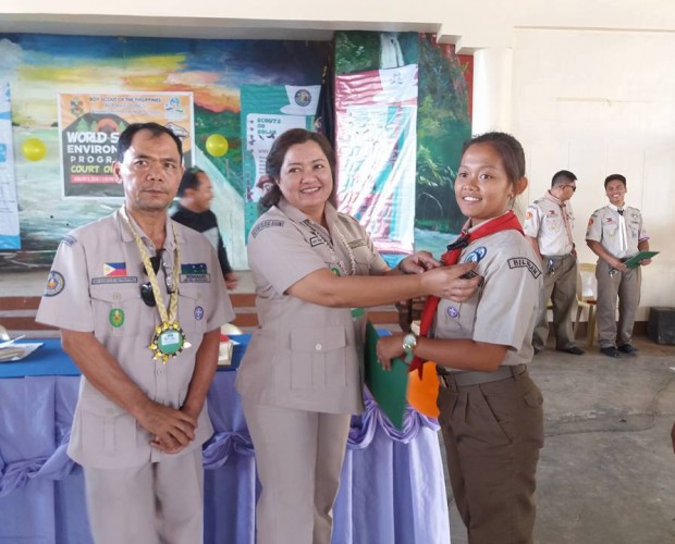 SDS Carmela Tamayo of DepEd Biliran (center) with OIC John Anthony Romagos of BSP Biliran Council (left) awards the WSEP Badge to a female Senior Scout. (Photo by Alma M. Atibula)
